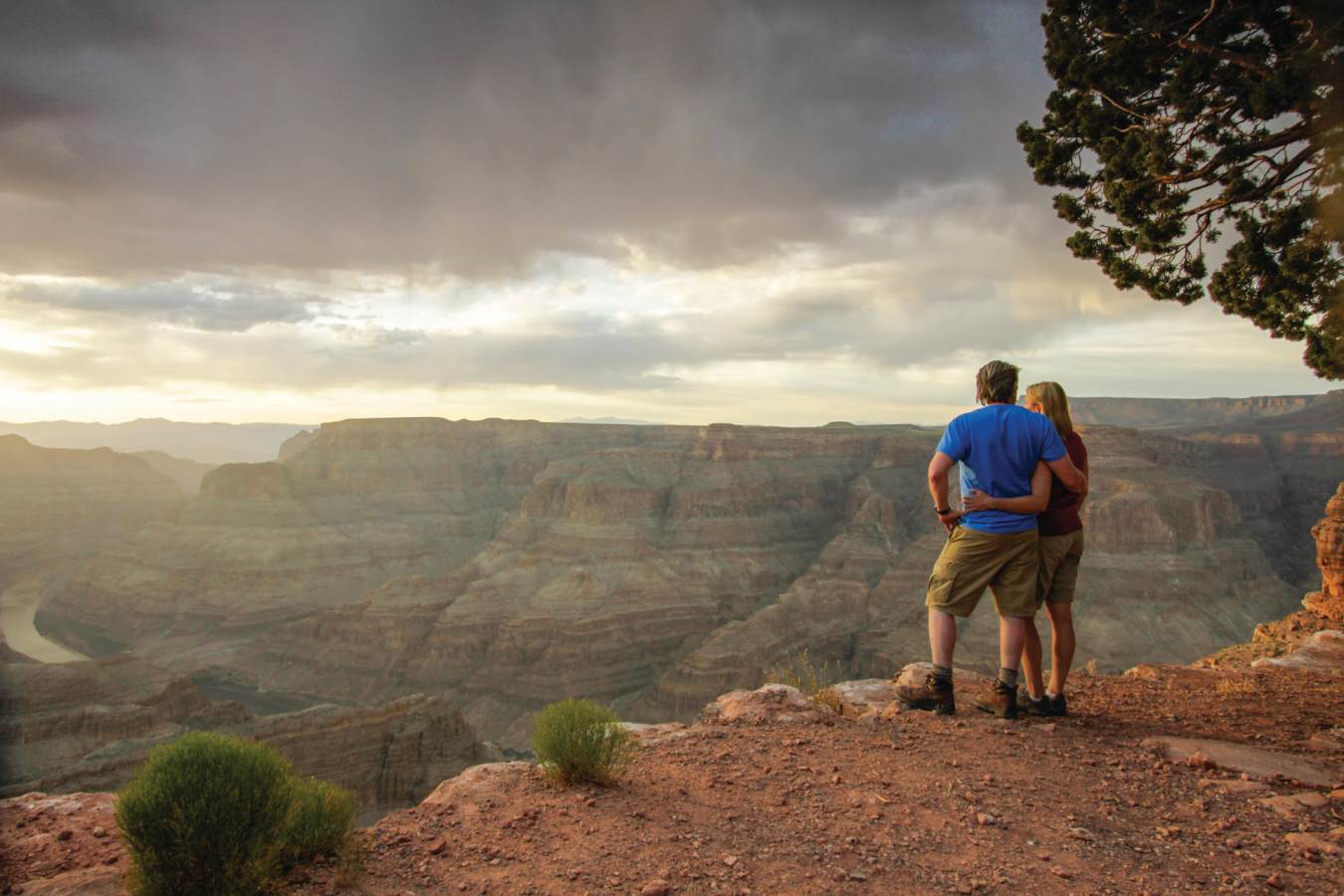 A couple standing at the edge of the Grand Canyon